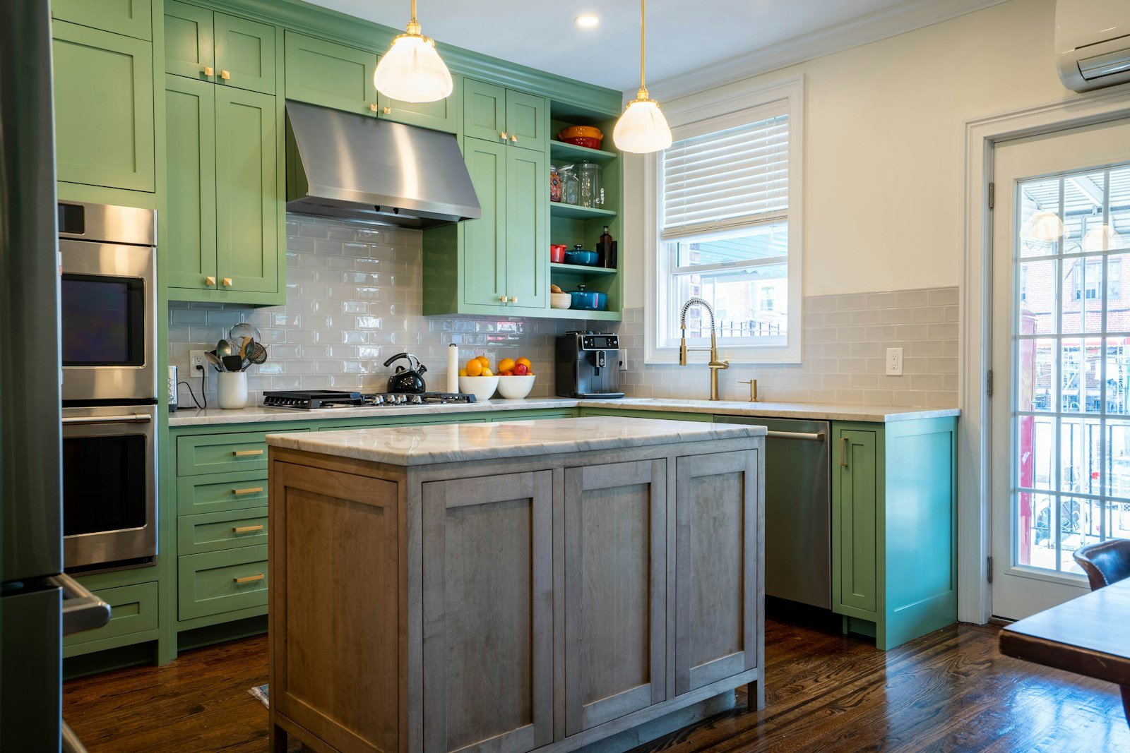 Jewel toned green kitchen cabinets with a centre island